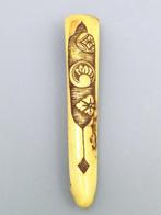 Obihasami Netsuke met een bloemmotief aan de voorkant en