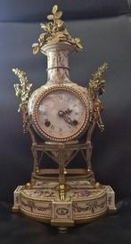 Tafelklok van fijn porselein met vergulde bronzen beslag -