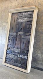 Drukblokken - een letterbak gevuld met een collage “WINE