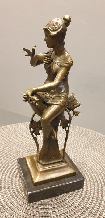 Nick - Beeld, girl sitting on a pole. grapes in her hand.