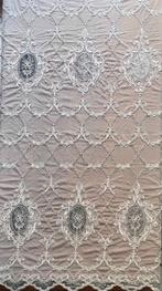 Weelderige tulle medaillons volledig met de hand geborduurd.