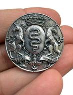 Vreemde militair heraldiekspeld in zilverkleurig metaal,