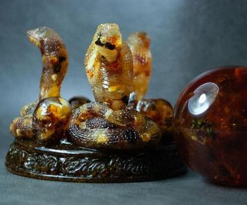 3 serpents de cobra en ambre balte tenant une boule dambre