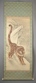 Een hangende rol die een woeste tijger in de sneeuw