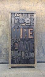 Drukblokken - een letterbak gevuld met een collage “WINE