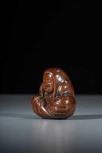Een mooie boxwood netsuke van een zittende Daruma met