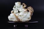 Boy seated on a dragon carp - Celadon and russet jade -