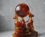 3 Baltische amber Sphynx katten die een amberbal met