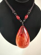 Collier pendentif ovale en ambre aux nuances miel et brun. -