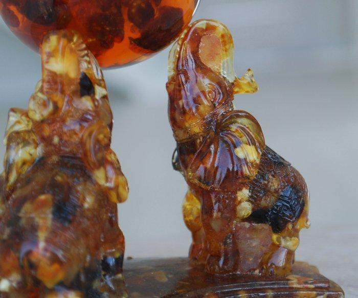 3 Baltische barnsteenolifanten die een barnsteenbal, Antiek en Kunst, Curiosa en Brocante
