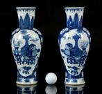 Een paar grote Chinese blauw-witte 100 Antiques en Prunus