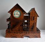 Groot miniatuur huisje met waterrad en niet werkende klok -