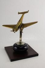 Figuur - Een messing vintage modelvliegtuig op een