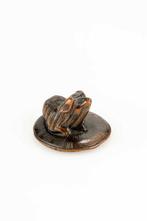 Un netsuke en bois représentant un chiot Pékinois assis sur