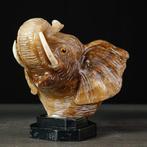 Met de hand gesneden olifantenhoofd van onyx op een zwarte