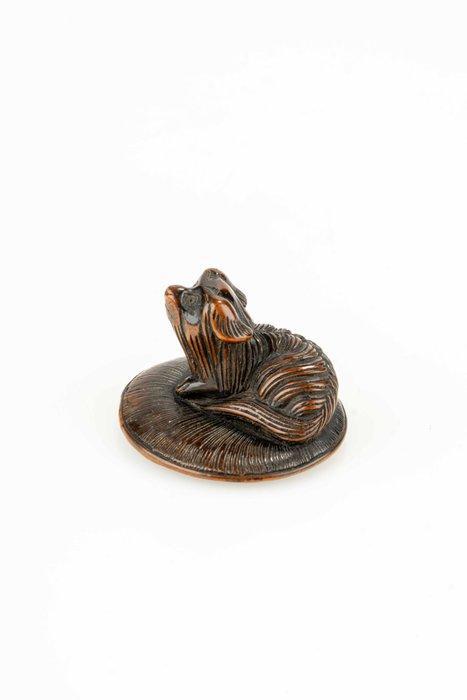 Een houten netsuke van een Pekingese puppy zittend op een, Antiek en Kunst, Antiek | Overige Antiek