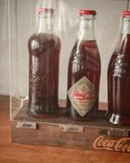 Collectie merkartikelen - Verzamelflessen in vitrine -